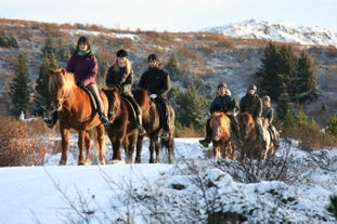 A line of horse riders exploring the snowy landscapes of Hafnarfjordur in Southwest Iceand.