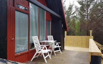 Bard Cottage has a patio with chairs, perfect for relaxing outside the house.