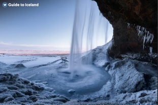 De Seljalandsfoss-waterval wordt in de winter omringd door sneeuw.