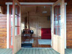 The entrance of the cabin leads into the lounge area, with a comfortable sofa and a flat-screen TV.
