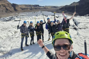 A group of people enjoy the thrill of glacier hiking on a sunny day.