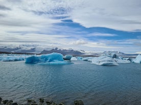 The icebergs float calmly towards the ocean in the glacier lagoon.
