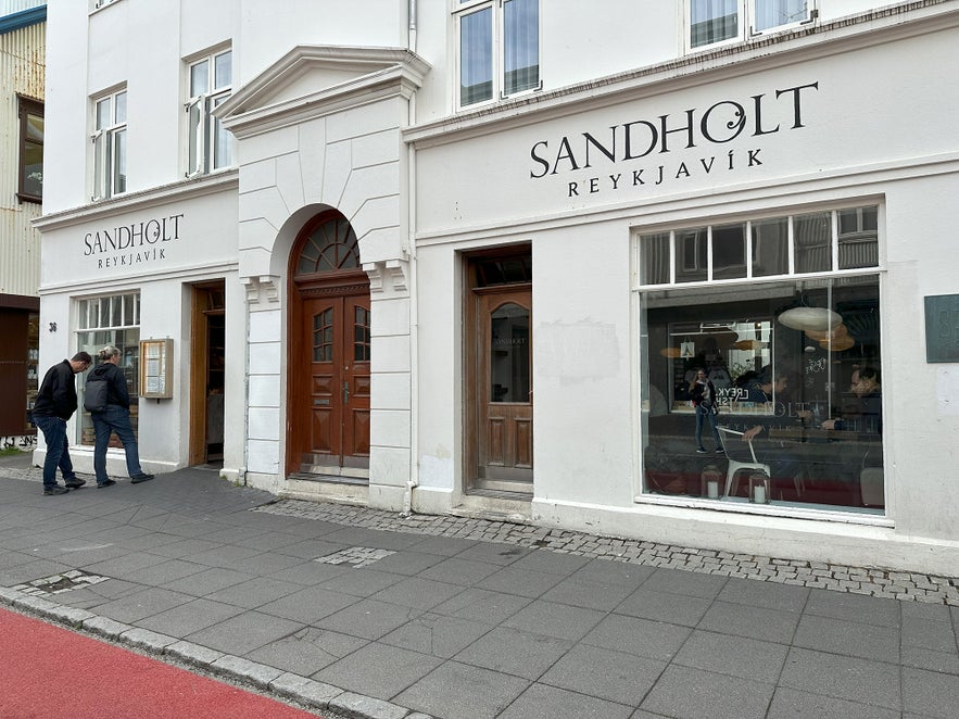 Front view of Sand Hotel and Sandholt Reykjavik bakery on Laugavegur street, a popular spot in downtown Reykjavik, Iceland.
