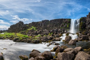 Oxararfoss waterfall in Thingvellir is surrounded by large rocks.