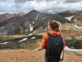 A hiker enjoys the breathtaking views of Landmannalaugar mountains in Iceland.