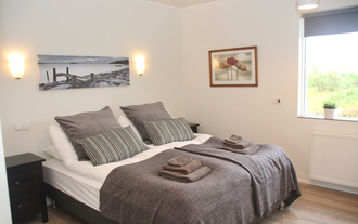 Lynghagi의 메인 침실에는 편안한 더블 침대가 있습니다.