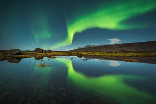 A band of aurora borealis decorates the winter skies of Iceland.