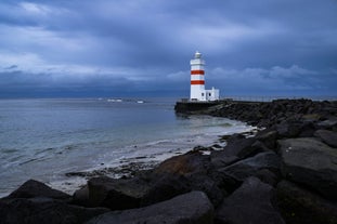 The beautiful Gardskagaviti lighthouse stands on the coastline of the Reykjanes peninsula.