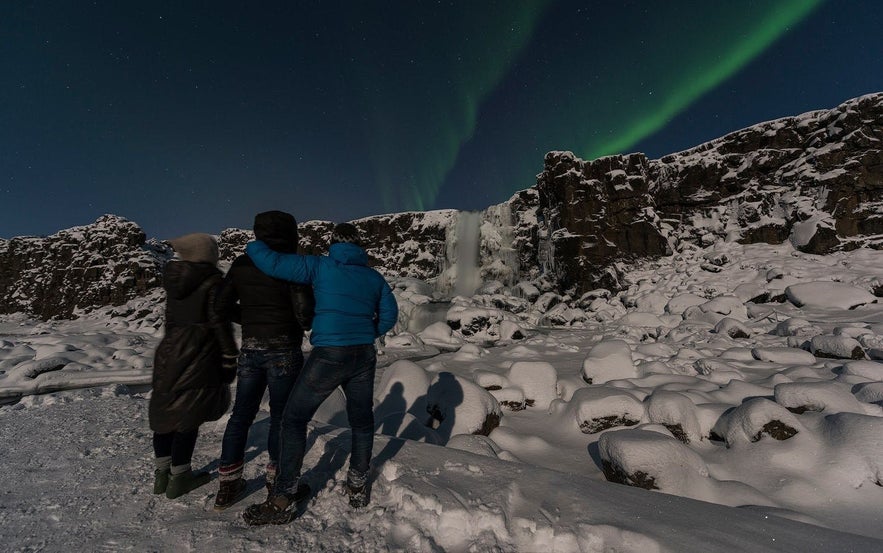 Travellers watching the northern lights in Iceland