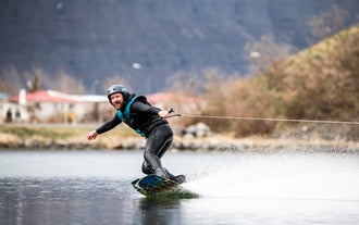 Mężczyzna cieszy się wakeboardingiem na islandzkich Fiordach Zachodnich.