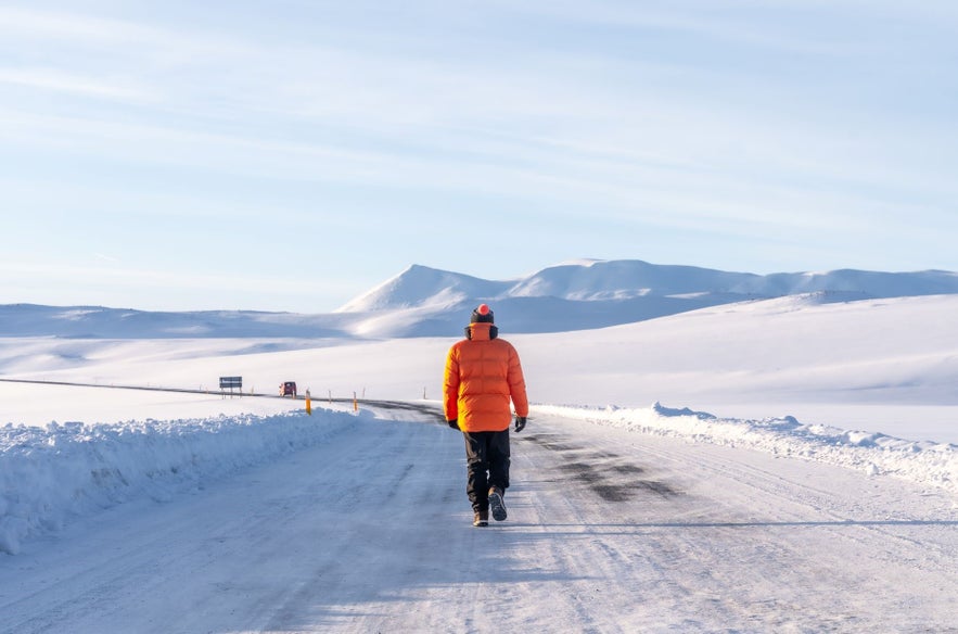 A man walks on an ice road in Iceland.