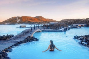 A woman bathes in the milky blue waters of the Blue Lagoon geothermal spa.