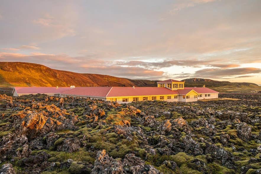 Hotel Northern Lights Inn in de met mos bedekte lavavelden bij de Blue Lagoon in IJsland, badend in het gouden uurlicht met indrukwekkende heuvels op de achtergrond.