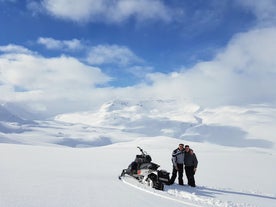 Two travelers strike a pose on the snowy terrain of the highlands.