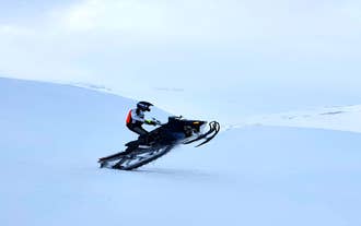 An expert snowmobile rider showing off a trick.