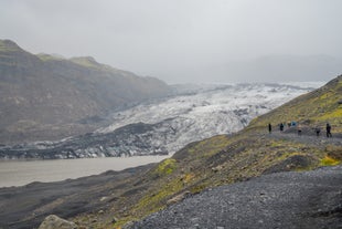 A group of travelers approaching the mouth of Solheimajokull glacier in Iceland.