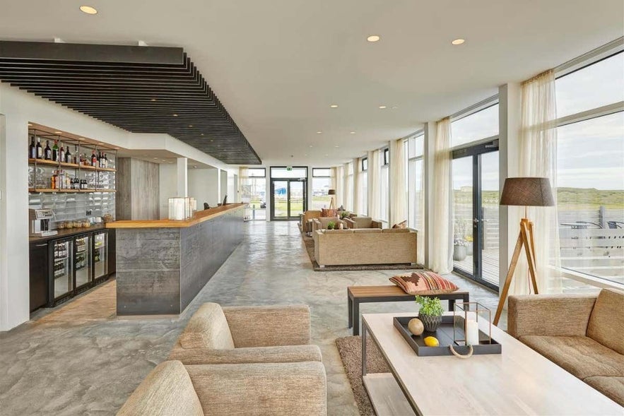 Элегантное лобби отеля Berjaya Hofn Hotel в Хёбне с современным интерьером, зоной отдыха и большими окнами.