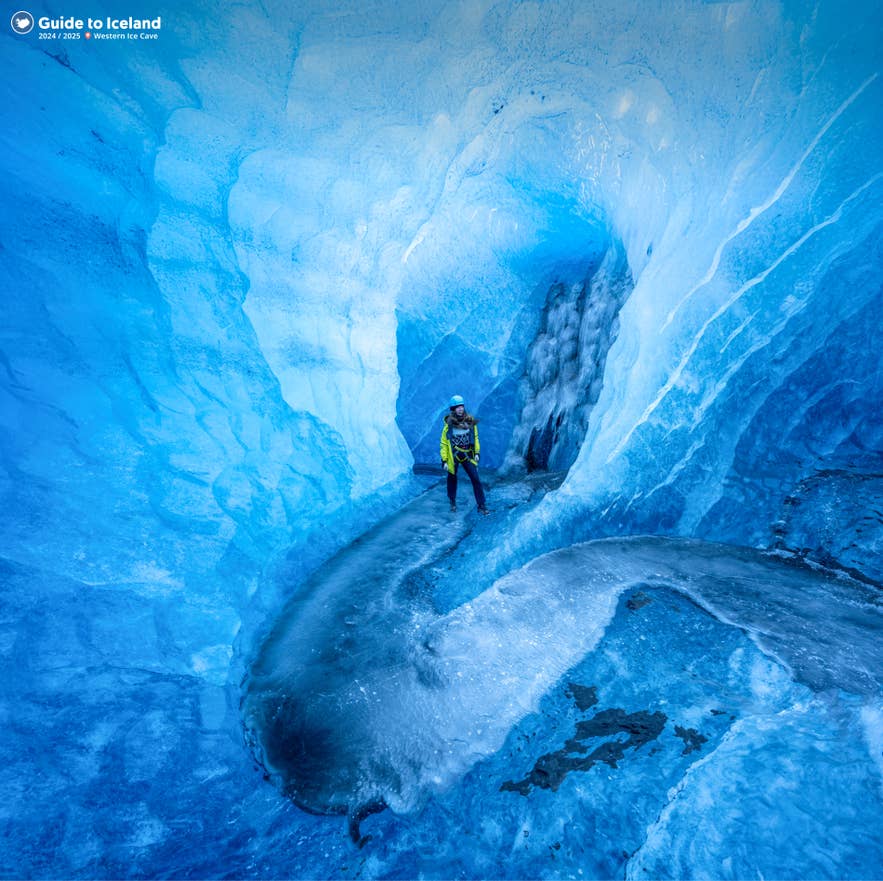 冬のアイスランド、ヴァトナヨークトル氷河のクリスタルブルーアイスケーブ内部を探検する旅行者