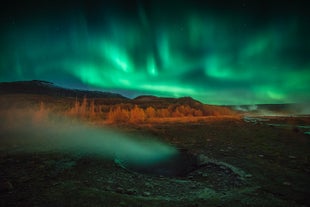 A beautiful display of aurora shines above a geothermal valley in Iceland.