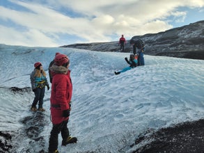 A small group of hikers enjoying a glacier tour in Solheimajokull.