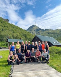 A group of women hikers wears their smiles while outside a mountain hut in Thorsmork.