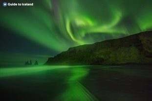 La aurora boreal en la playa de arena negra de Reynisfjara