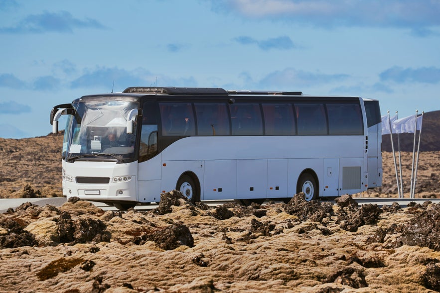Kør til Den Blå Lagune i Island. Foto af en shuttlebus i det islandske landskab.