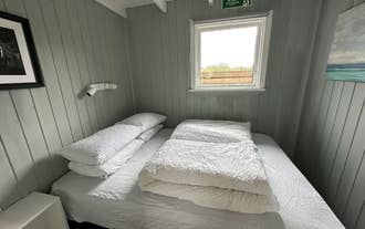A double bedroom at Cave Cabins with the sheets folded on top of the bed.