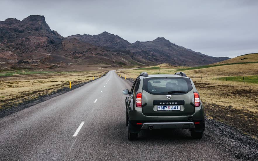 A rental SUV on an empty road through the mountains of the Reykjanes Peninsula
