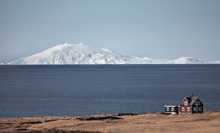 Vista del ghiacciaio e vulcano Snaefellsjokull coperto di neve, visto dalla costa della penisola di Snaefellsnes, nell'Islanda occidentale.