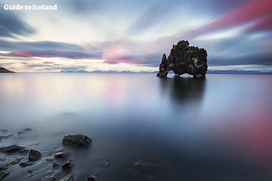 The Hvitserkur sea stack at sunset, a unique basalt rock formation located in a scenic fjord in Northern Iceland.