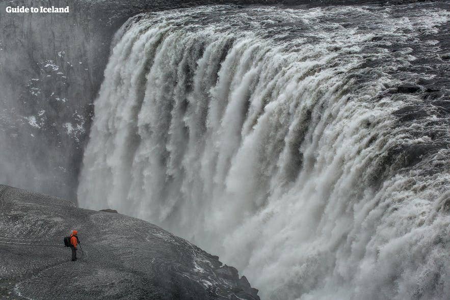 Visitor standing at the viewpoint overlooking Dettifoss Waterfall.