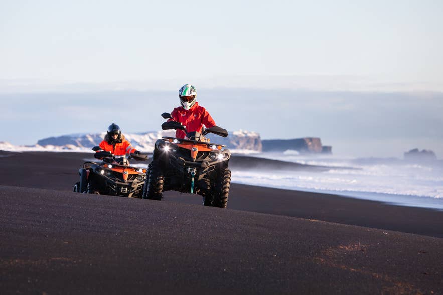 Driving an ATV across the black volcanic sands near Vik in South Iceland