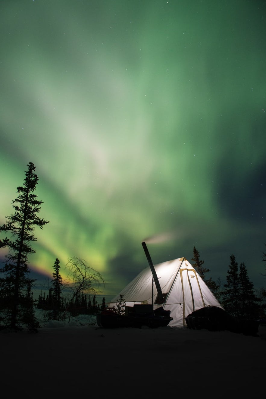 A tent in Iceland in the countryside under the Aurora Borealis.