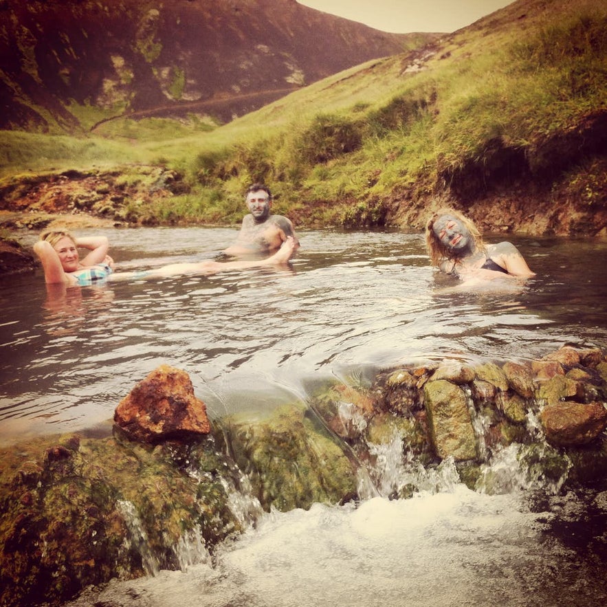 Travelers enjoying a hot spring river in Reykjadalur