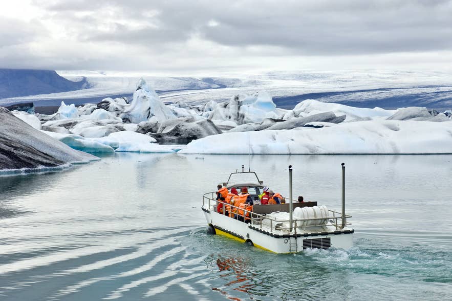 Amphibian boat carrying passengers among icebergs on Jokulsarlon Glacier Lagoon