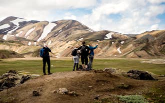 Visitors admire rhyolite mountains during a Highlands Super Jeep tour in Iceland.