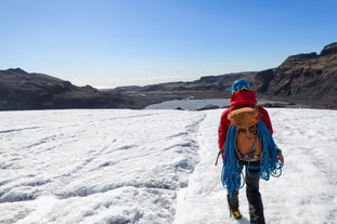 Une femme marche sur la glace du glacier Vatnajokull en Islande.