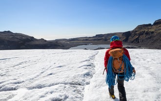 Une femme marche sur la glace du glacier Vatnajokull en Islande.