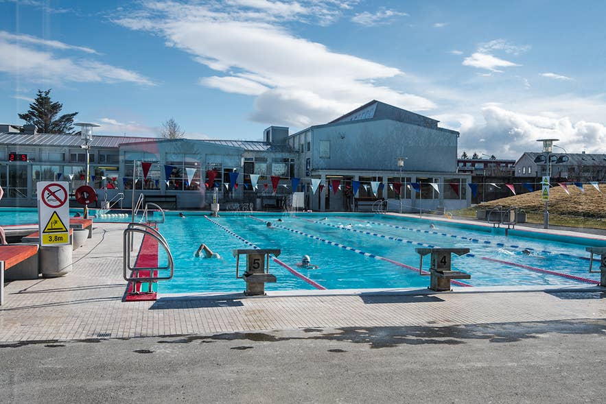 Außenbecken mit Schwimmbahnen bei Sonnenschein im Vesturbaejarlaug, einem der ruhigsten Schwimmbäder Reykjaviks