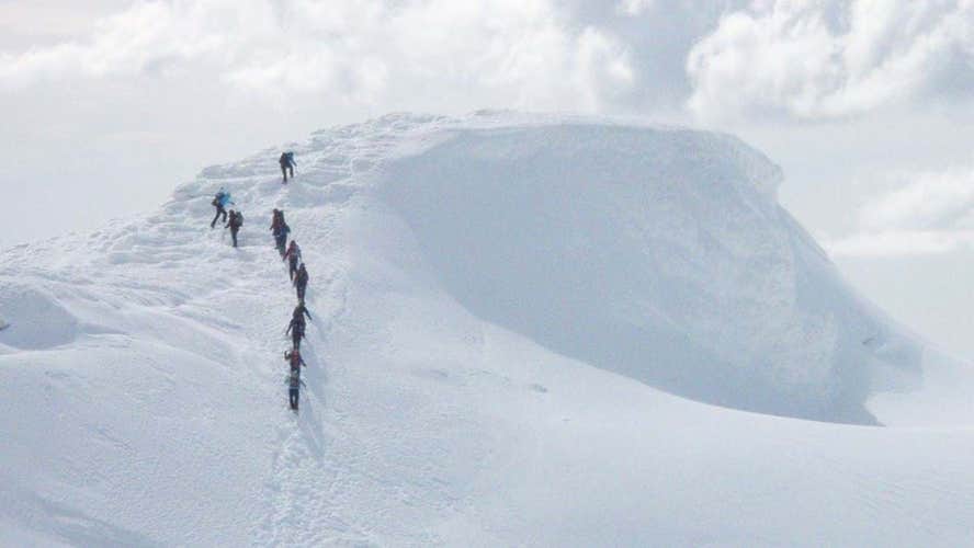Hikers conquering the snowy landscapes of the Eyjafjallajokull glacier volcano.