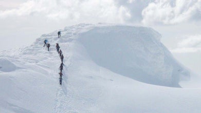 Hikers conquering the snowy landscapes of the Eyjafjallajokull glacier volcano.