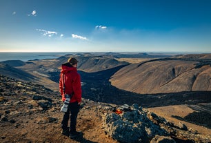 A hiker-photographer admiring the fresh lava fields of the Reykjanes peninsula in Iceland.