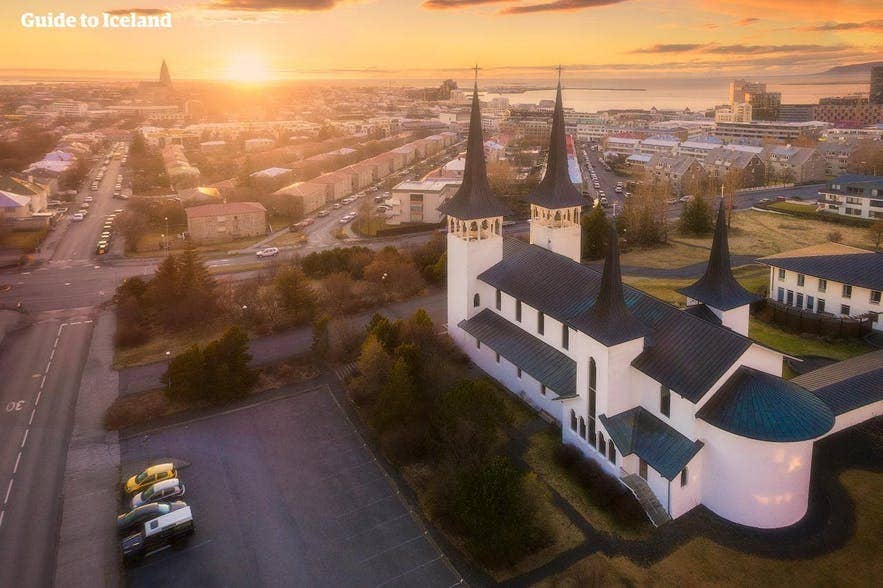 Вид на церковь Хатейгскиркья на закате в Рейкьявике, городской пейзаж на фоне.