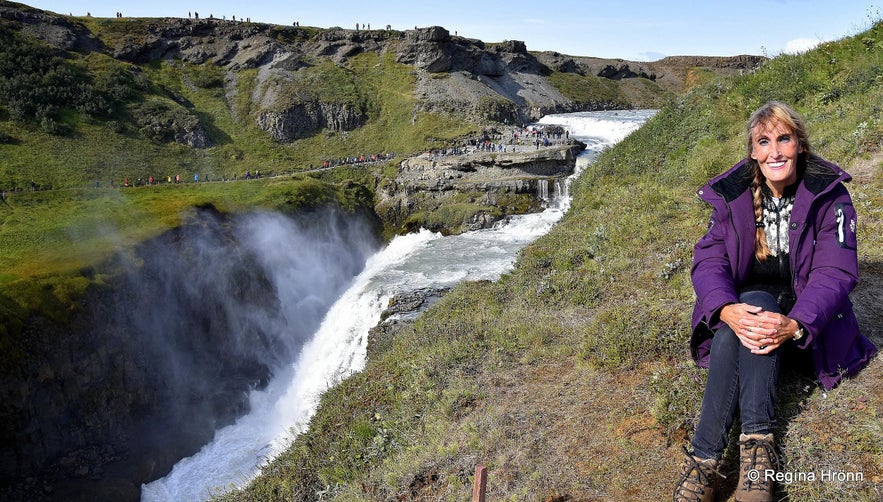 Besucherin am Ost-Aussichtspunkt mit Blick auf den Gullfoss-Wasserfall und die unteren Plattformen in Island.