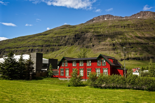 Hafaldan HI Hostel | Old Hospital sits underneath a mountain.