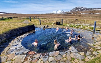 8 peole enjoy a soak at Laugarfell hot spring during a 4x4 Highlands tour from Egilsstadir.