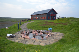 A Laugarfell hot spring filled with guests enjoying its waters. 