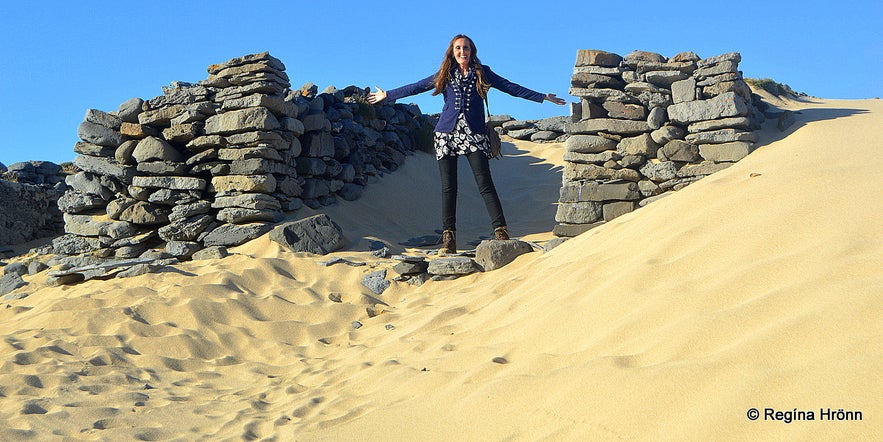 Regína by some of the ruins on the beach in Kollvík