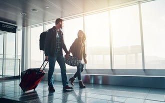 Ein Pärchen geht durch den Flughafen, bereit für den Flug.